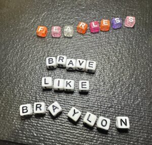 Simple white letter beads spelling Braylon Strong on handmade bracelet design