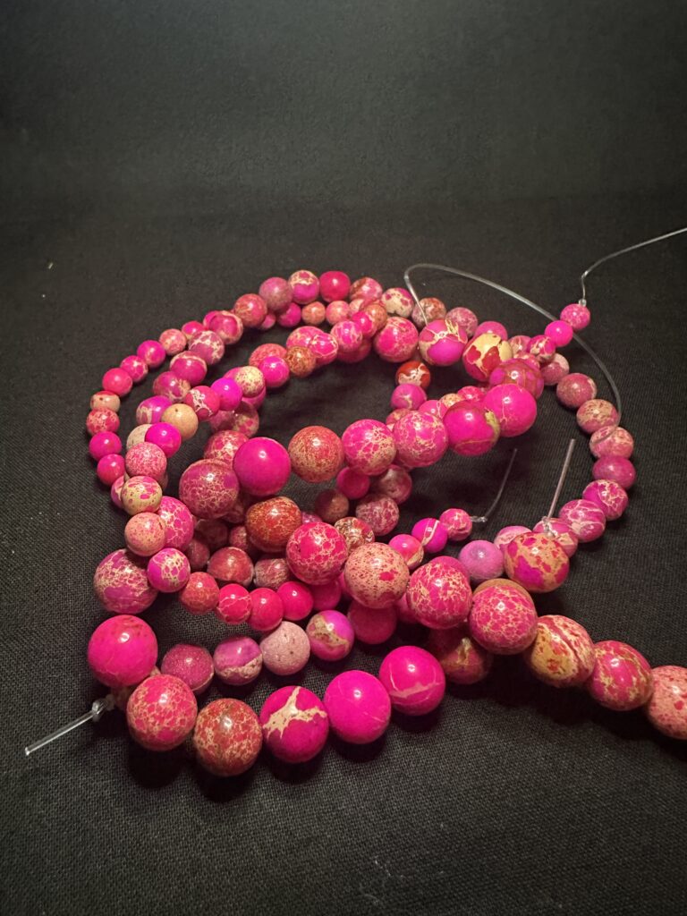 Amethyst in multiple forms β raw crystal, polished round beads, faceted beads, and tube cuts β illustrating natural variation documented in the Stone Library.